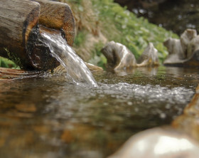 Fließendes Wasser aus einem Holzbrunnen - Nahaufname